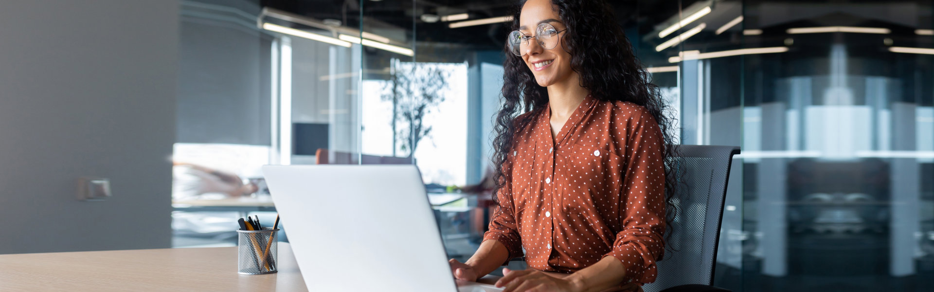 cheerful woman working on her laptop at the office