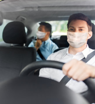 Health protection, safety and pandemic concept - male taxi driver wearing face protective medical mask driving car with passenger