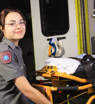  A paramedic person with his stretcher close to the ambulance