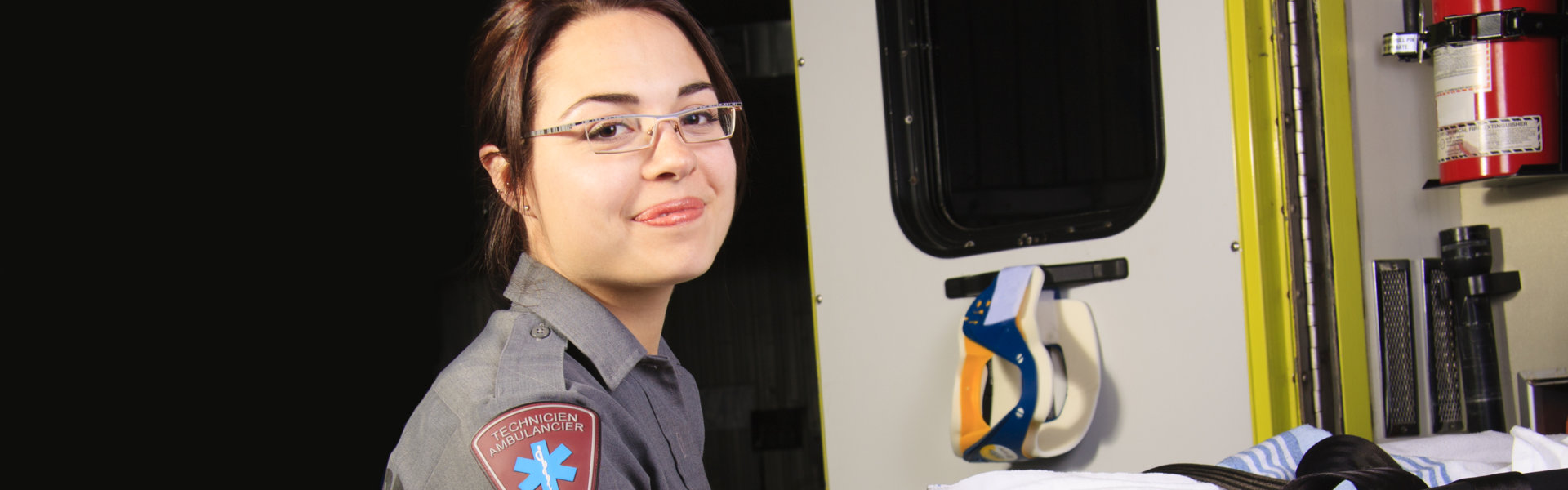 A paramedic person with his stretcher close to the ambulance